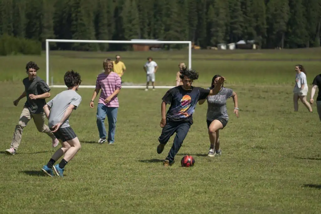 Teens at Turning Winds playing soccer in the grounds